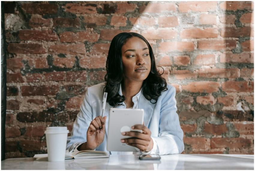 Businesswoman with a tablet sits thoughtfully in a