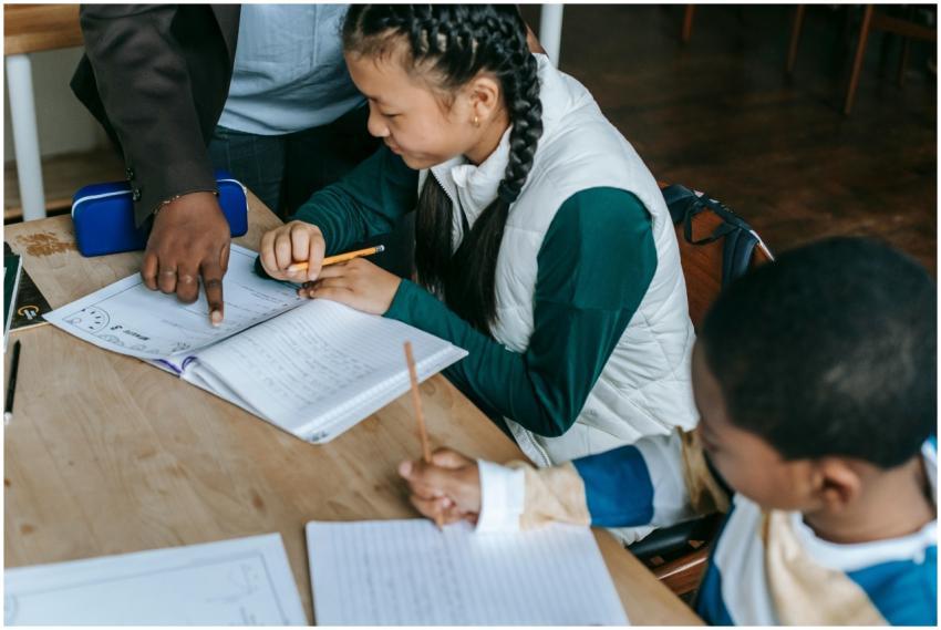 Crop African American teacher standing near desk w