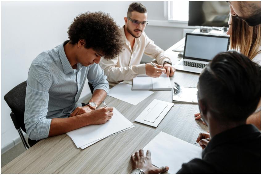 A multi-ethnic group working together at a desk wi