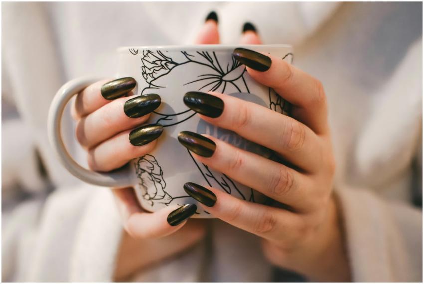 A close-up of manicured hands holding a decorative