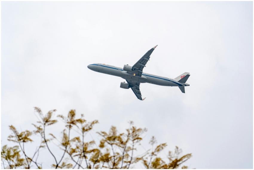 A low-angle view of a commercial airplane flying o