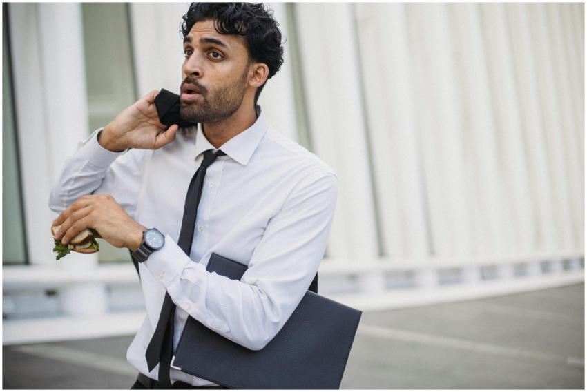 A businessman in corporate attire multitasking wit