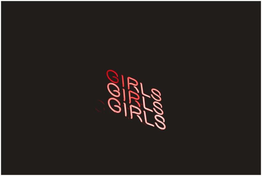 Vibrant neon sign displaying the word 'Girls' in r