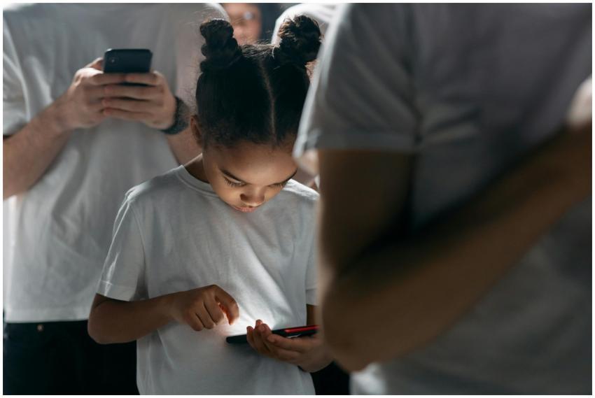 A young girl engrossed in her smartphone amidst a