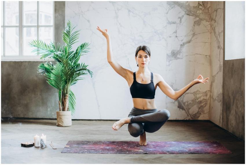 A woman practices yoga indoors on a mat, embodying