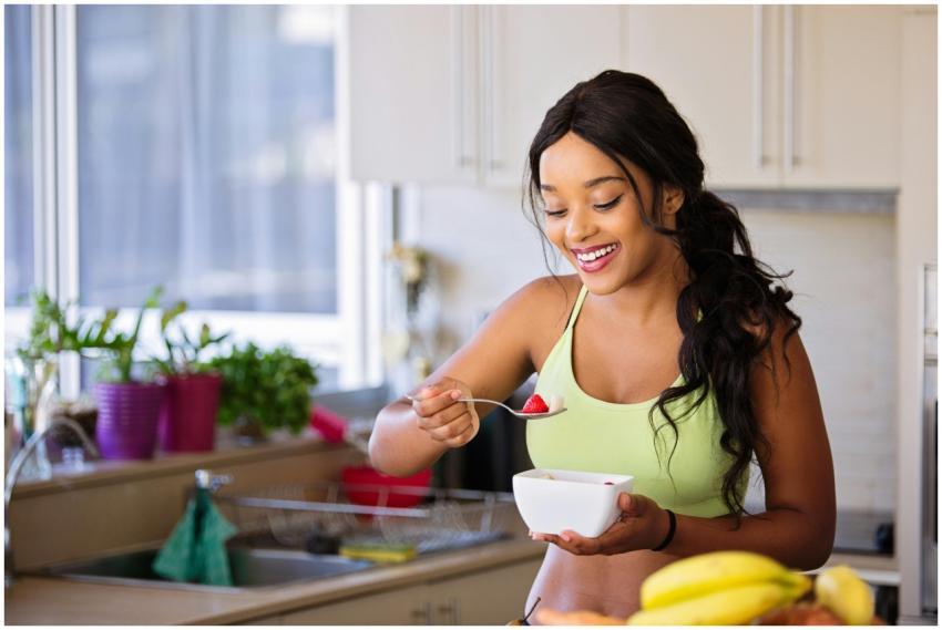 Smiling woman eating a nutritious fruit bowl in a