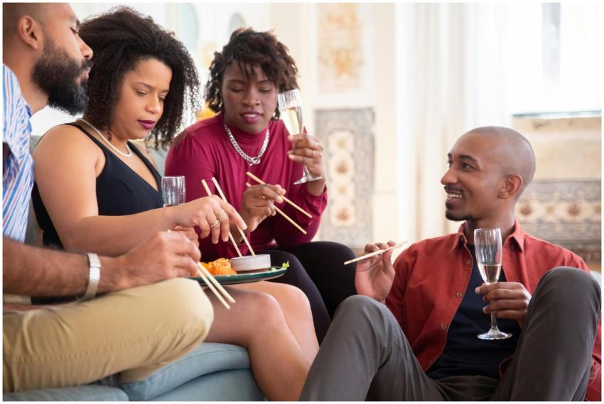 A group of diverse friends enjoying sushi and wine