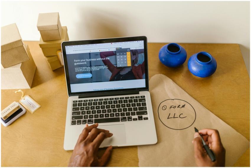 Workspace with laptop, packaging, and handwritten