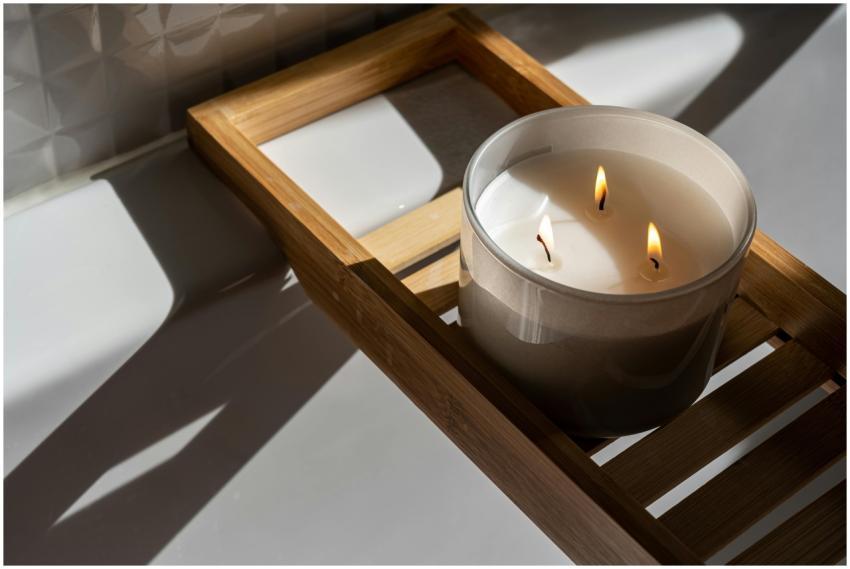 A minimalist setting with a lit candle on a wooden