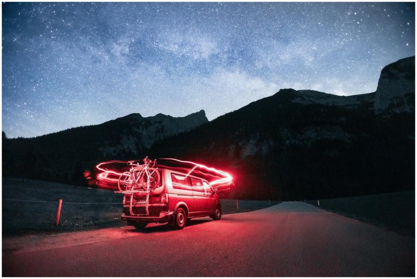 A camper van with bicycles under a stunning night