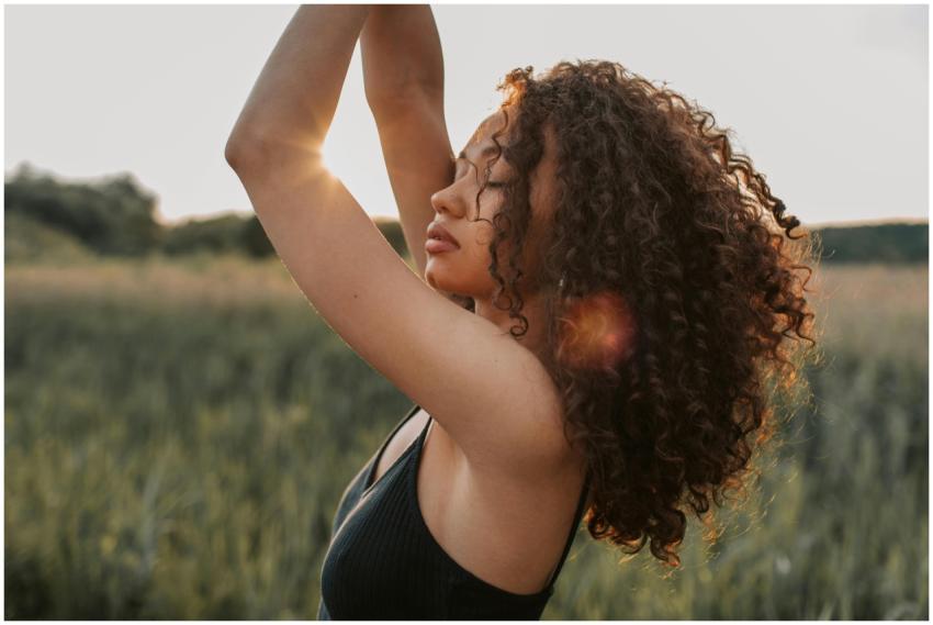 A fashionable woman with curly hair poses confiden