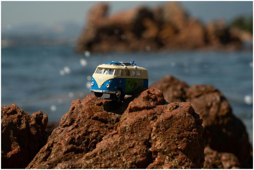 A toy Volkswagen van placed on eroded rocks by the