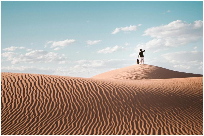 A lone traveler atop a sand dune in Al Wahat Al Da
