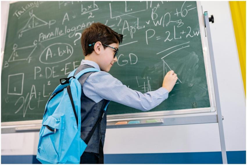 A young boy with glasses solving math equations on