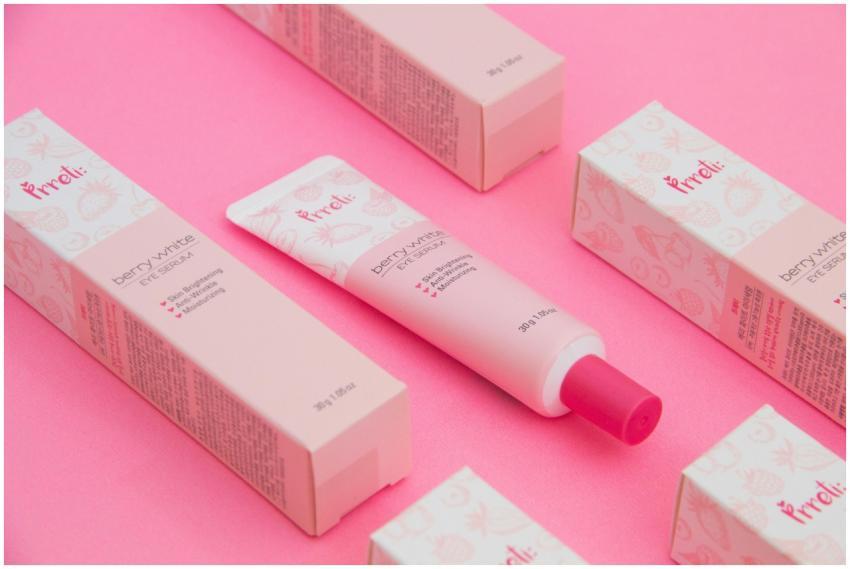 Pink-themed flat lay of berry-white eye serum with