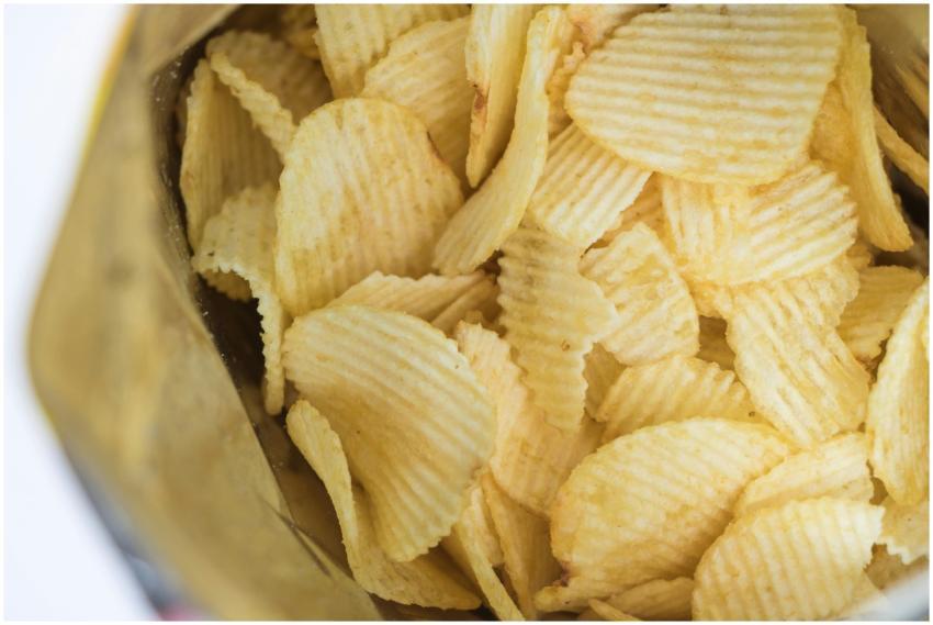 Close-up of ridged potato chips in an open bag, sh