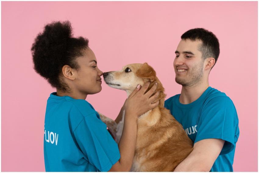 Two volunteers enjoying a happy moment with a dog