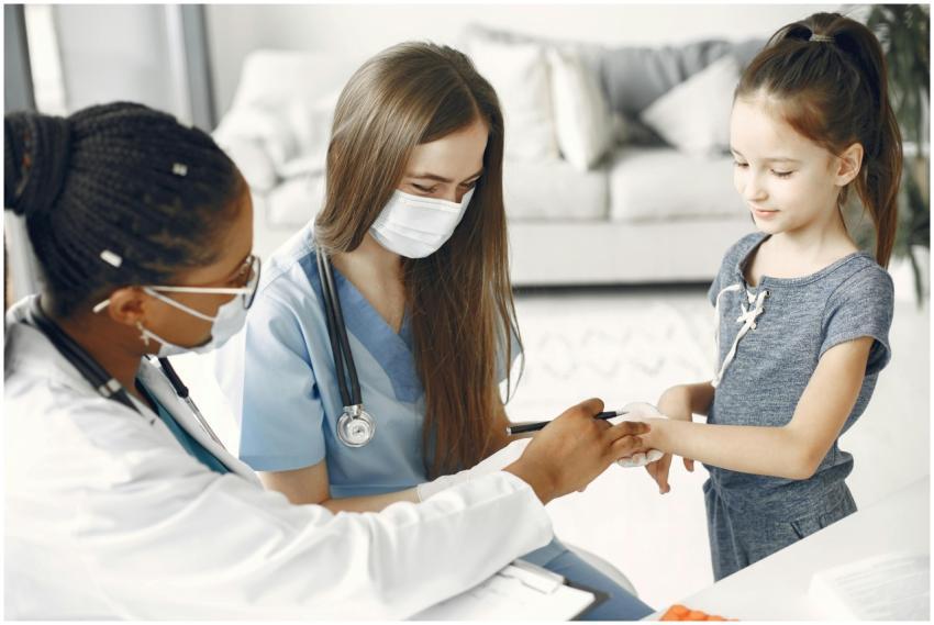 Doctors and a nurse wearing masks attending to a c