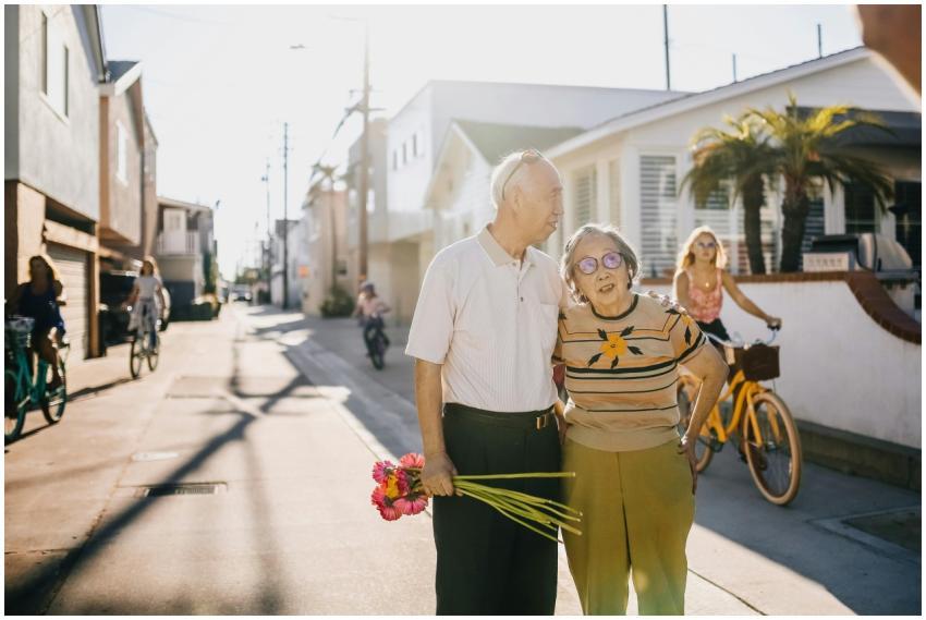 Elderly couple enjoying a walk with flowers in a s