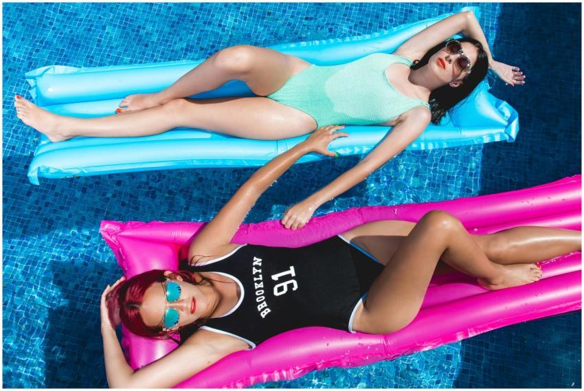 Two women relaxing on colorful floats in a swimmin
