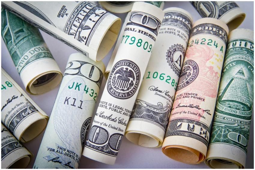 Close-up of rolled US dollar bills symbolizing wea