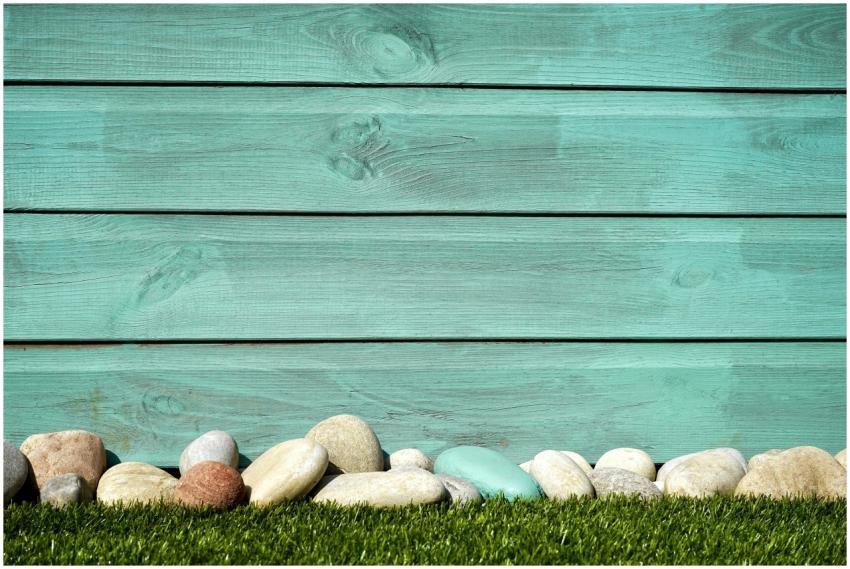 Turquoise wooden planks with pebbles and grass, pe