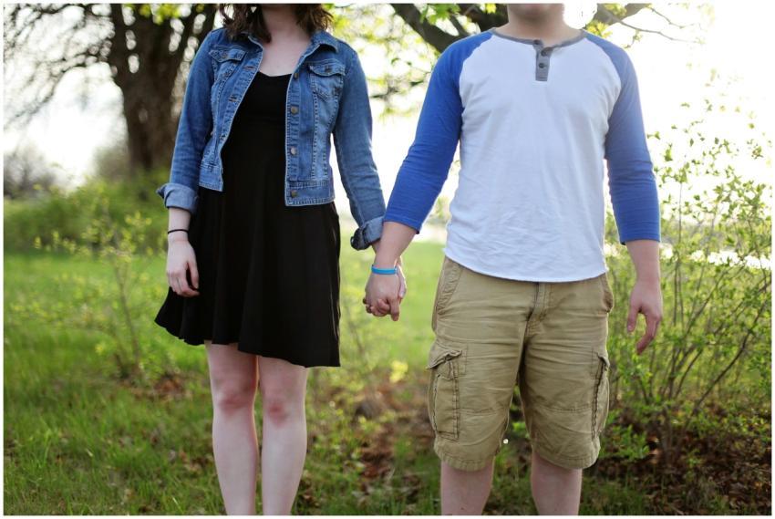 A young couple holding hands outdoors in a park, e