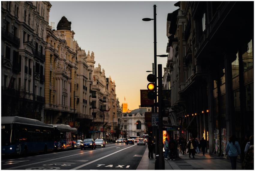Bustling street scene in Madrid at dusk, featuring