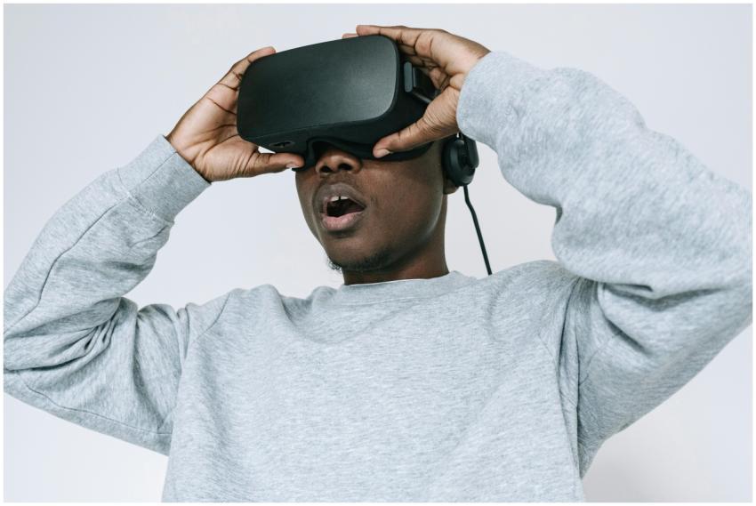 Black man wearing VR glasses showing amazement on
