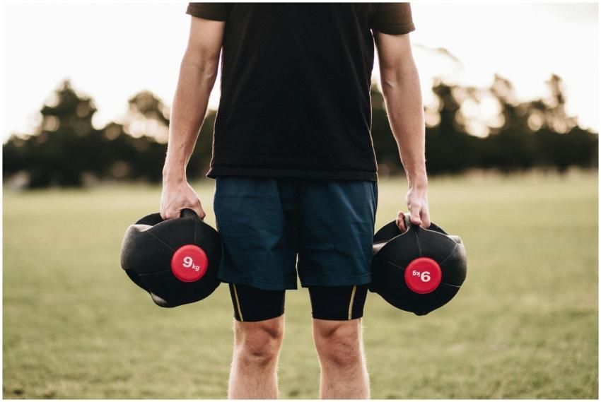 Man exercising outdoors with medicine balls in a p