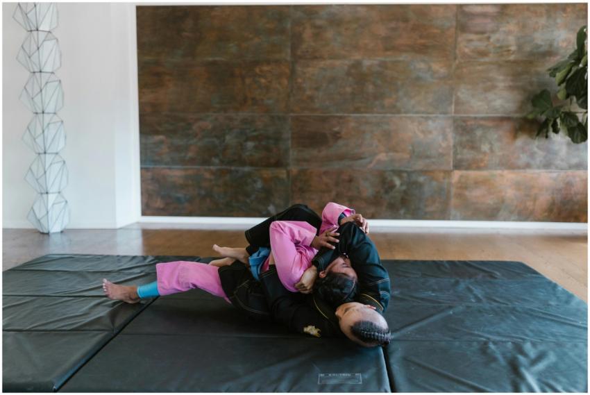 Martial artists in grappling position on mats duri