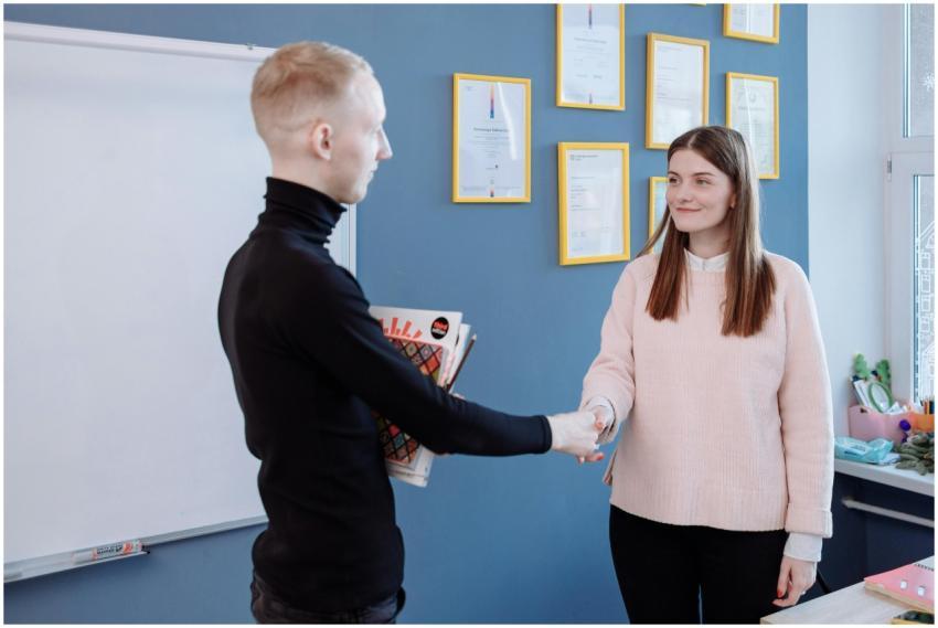 Man and woman exchanging handshake in office envir