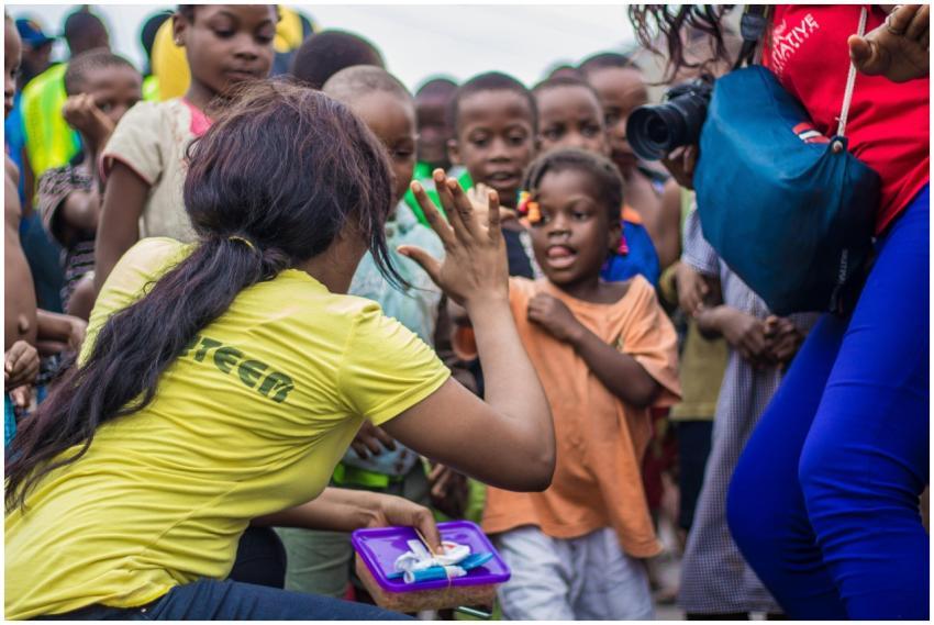 A woman engages with children through a high-five