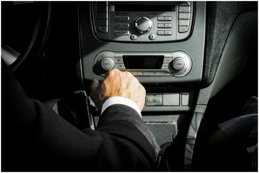 Close-up of a driver in a suit operating the car d