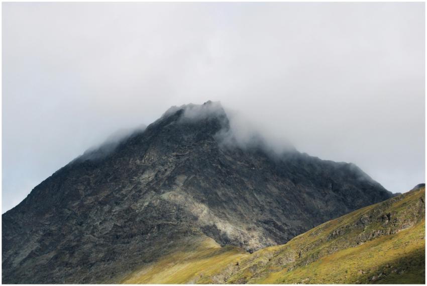 Majestic mountain peak shrouded in mist, showcasin