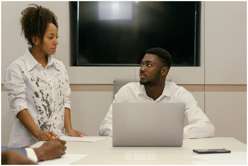 Two colleagues in a modern office engaging in a bu