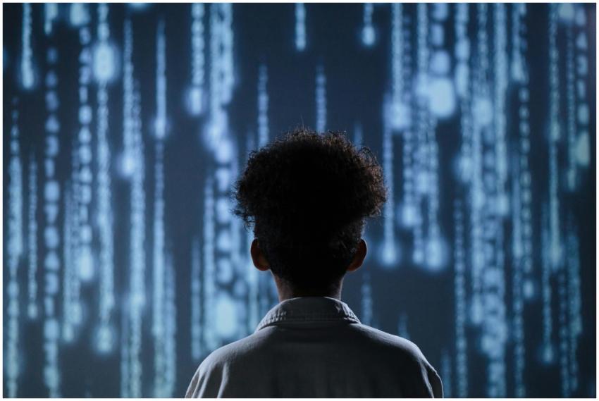 A young boy viewing a digital screen with data str