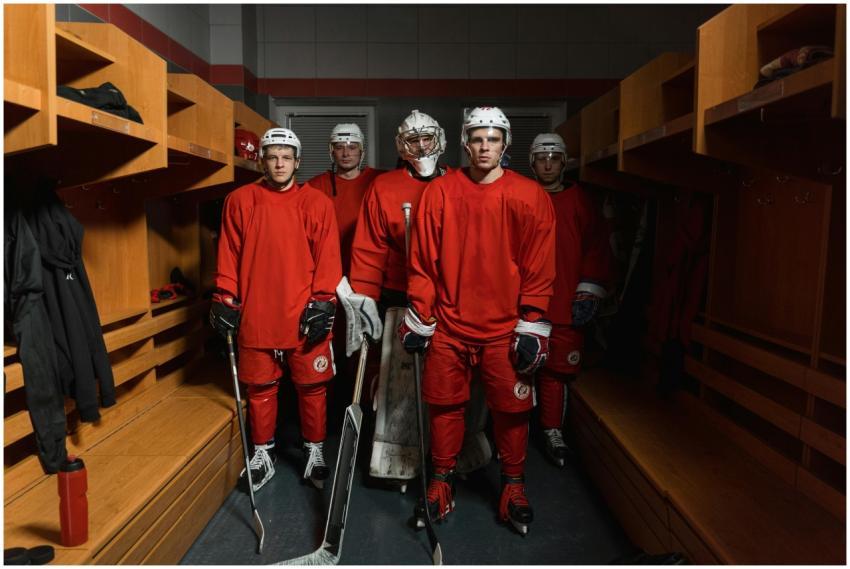 Ice hockey players in red uniforms readying up in
