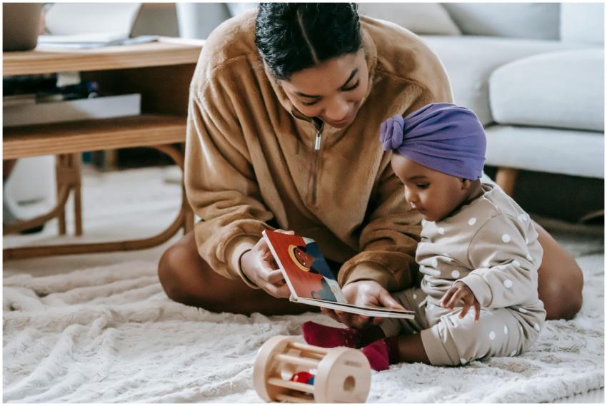 A mother and her baby bonding over a book on the f