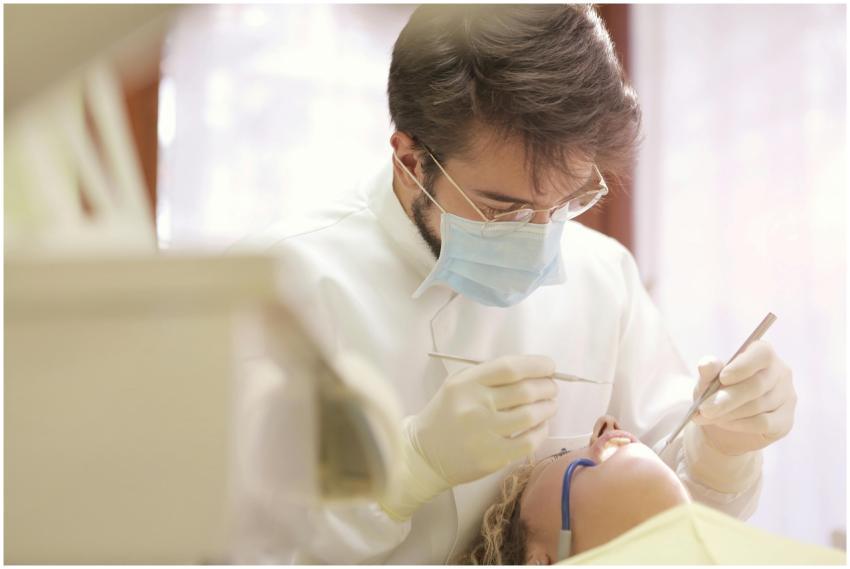 Dentist in face mask conducting a dental examinati