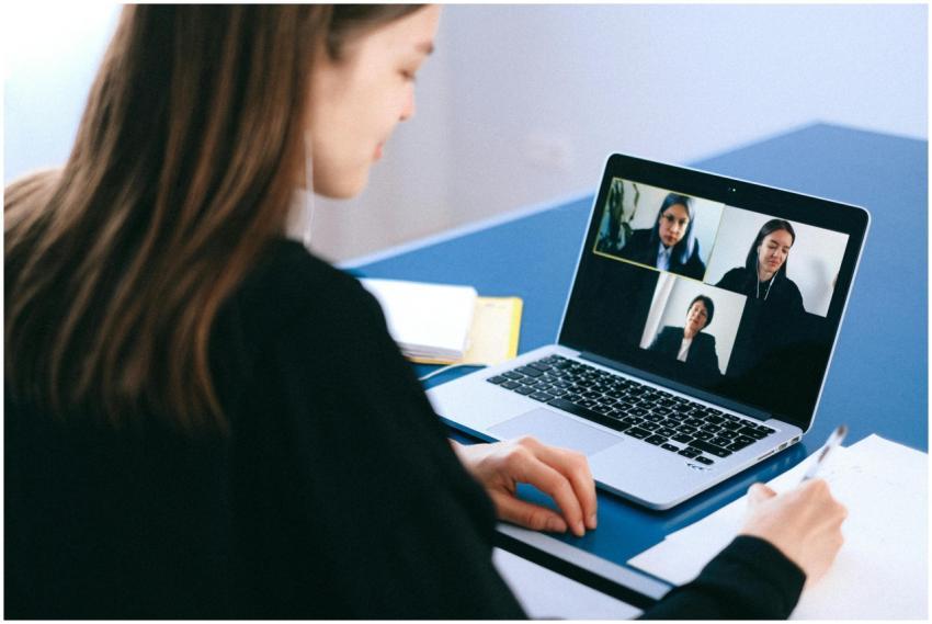 A woman engaging in a video conference using a lap