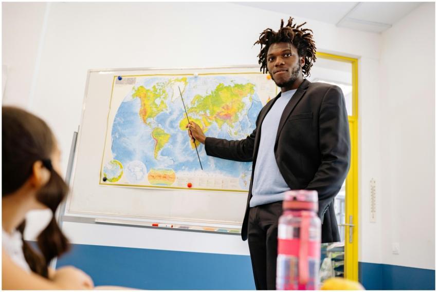 Male teacher using a pointer to describe a world m