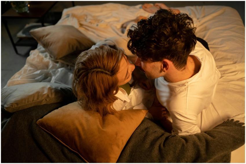 A close-up view of a loving couple lying face to f