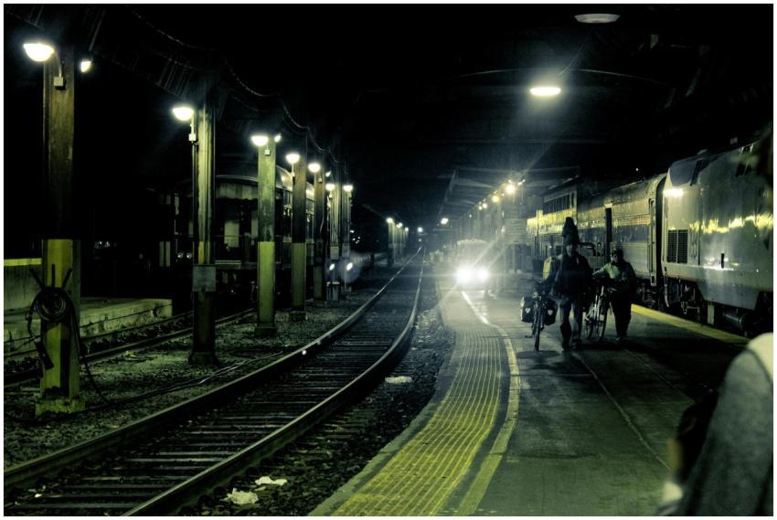 Dramatic night view of a train station with tracks