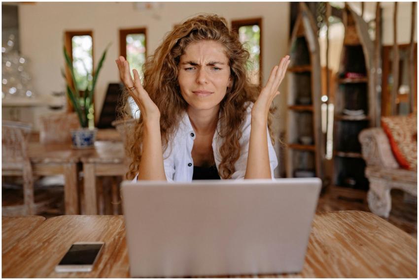 A woman frustrated with her laptop while working r