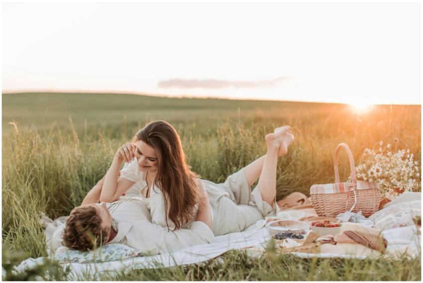 Couple enjoying a romantic picnic at sunset in a s