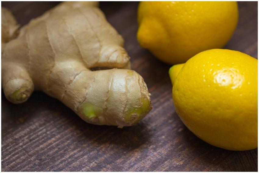 Close-up of fresh ginger root and lemons on a wood