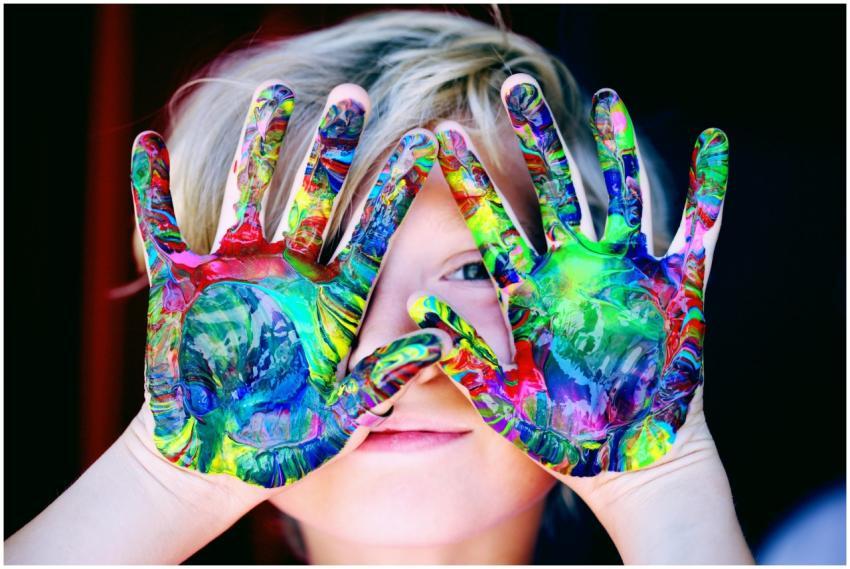 Vibrant close-up of a child's hands covered in col
