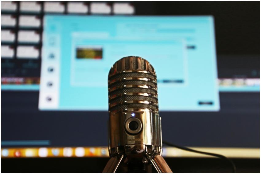 Close-up of a microphone with a blurred computer s