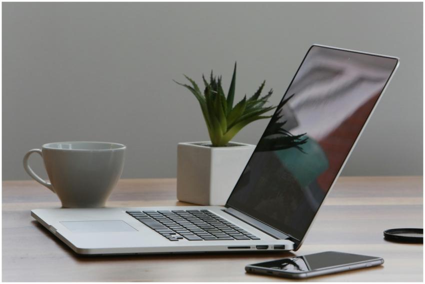 Minimalist home office desk with laptop, smartphon